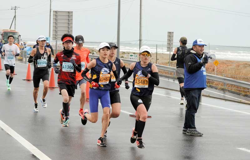 九十九里有料道路を走るハーフマラソンの部参加ランナー＝２５日、九十九里町