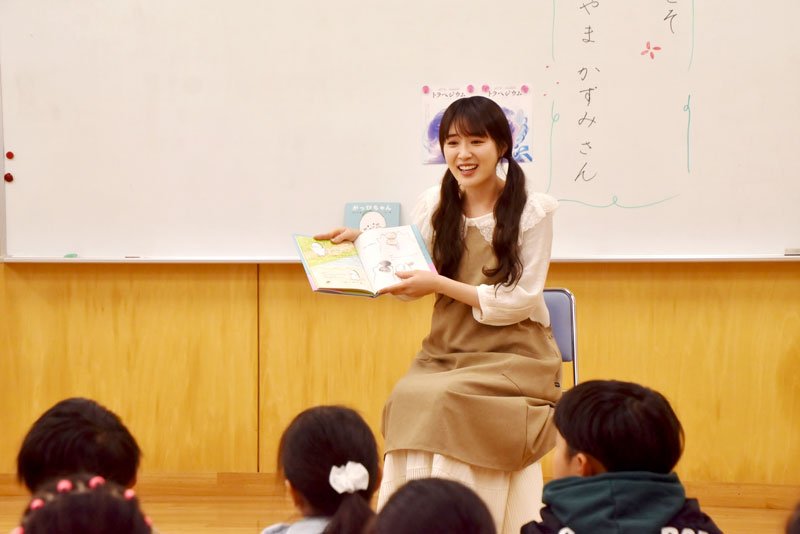 母校の子どもたちに自身の絵本を朗読する高山さん＝南房総市
