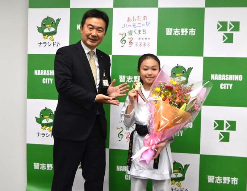 金メダルを手に優勝を報告する千葉さん（右）＝習志野市役所
