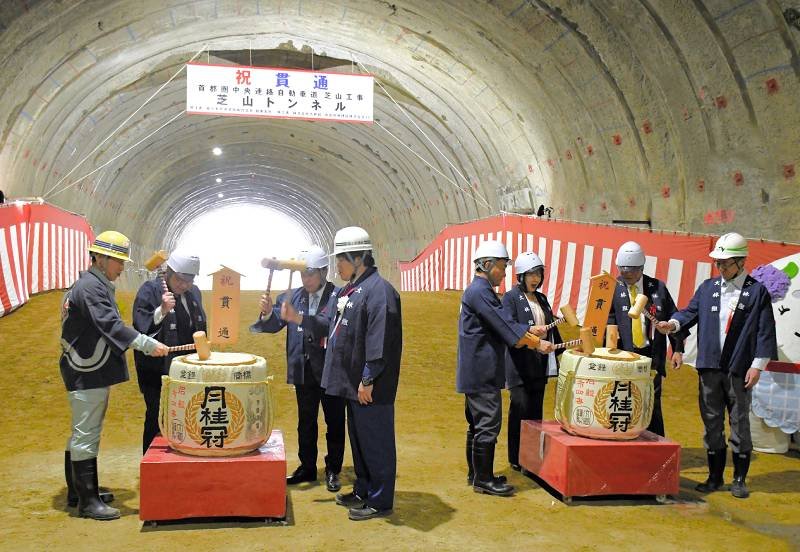 芝山トンネル貫通を記念して鏡開きに臨む施工事業者や自治体関係者ら＝２５日
