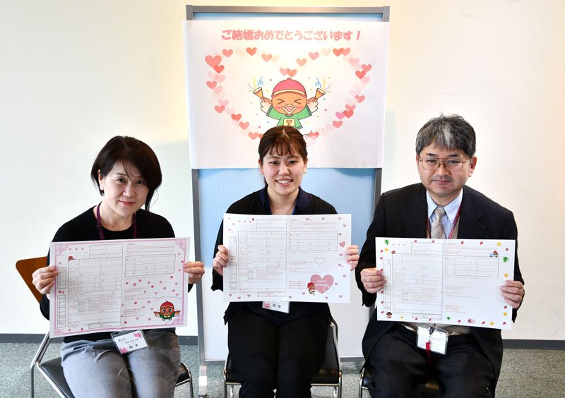 町のイメージキャラクター「コジュリンくん」をデザインに取り入れた東庄町のオリジナル婚姻届を紹介する職員＝東庄町役場