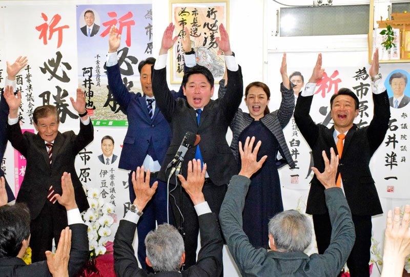 支援者と万歳をして、茂原市長選に初当選の喜びを分かち合う市原淳氏（中央）＝２１日夜、茂原市町保の事務所
