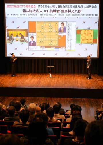 成田山新勝寺で行われる名人戦第２局の戦況を木村九段（右）らが説明する大盤解説会＝２４日、成田市

