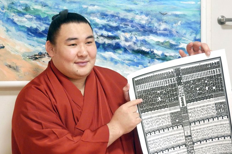 新入幕を果たし、番付表を持つ欧勝馬＝東京都墨田区の鳴戸部屋（共同）

