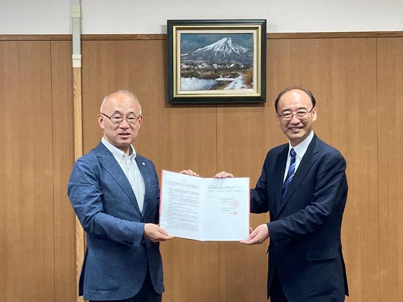 覚書を持つ川口会長（左）と小林学部長＝千葉市稲毛区
