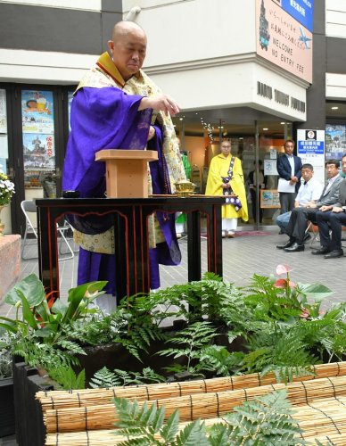 ウナギを放す放生池を清める成田山新勝寺の僧侶＝１２日、成田市
