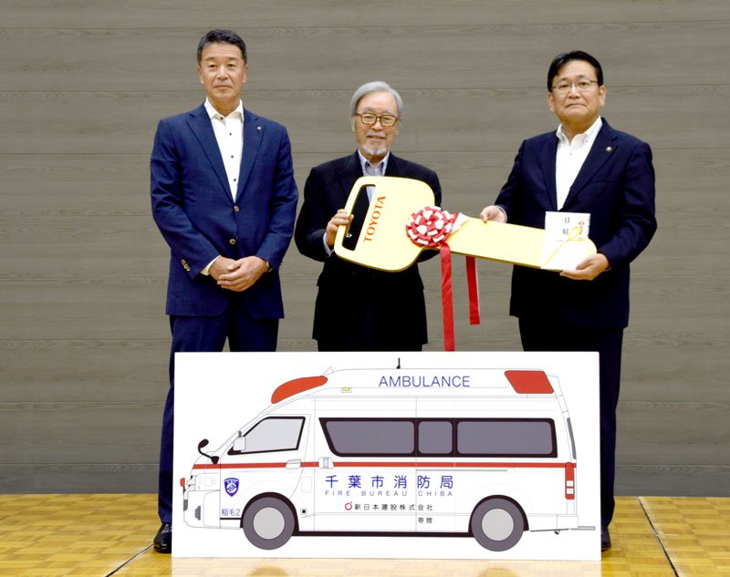 神谷市長（右）に目録とレプリカキーを手渡す金綱会長（中央）と高見社長＝千葉市中央区