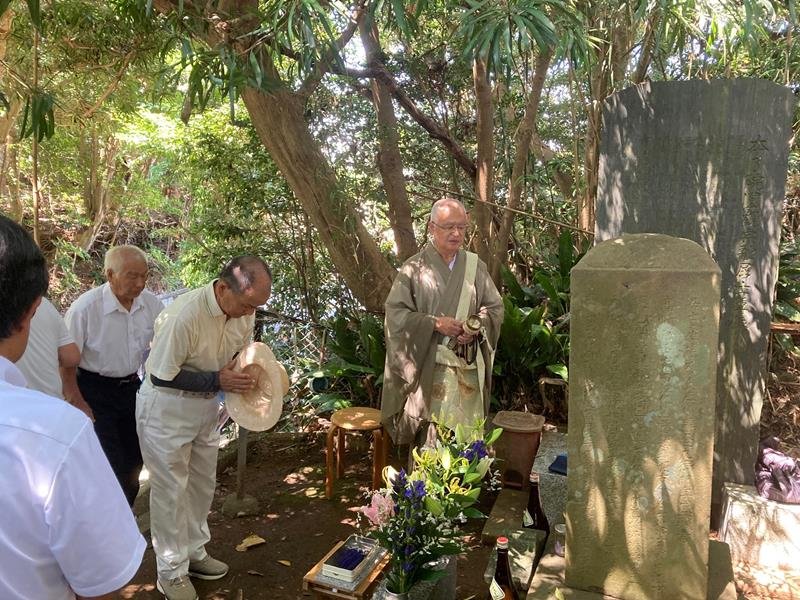 杢左衛門をたたえる石碑前で手を合わせる人たち＝銚子市
