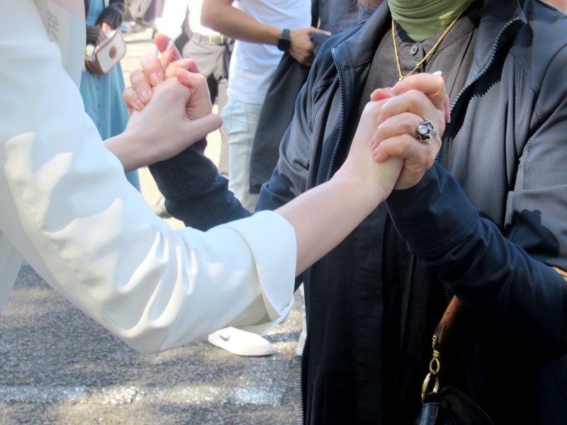 支持者の手を握りしめる候補者＝１５日、市川市