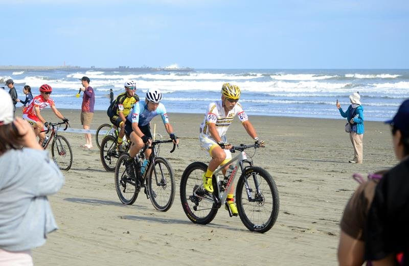 砂浜を自転車で周回するスポーツ「ビーチクロス」で、九十九里浜を走る選手ら＝九十九里町
