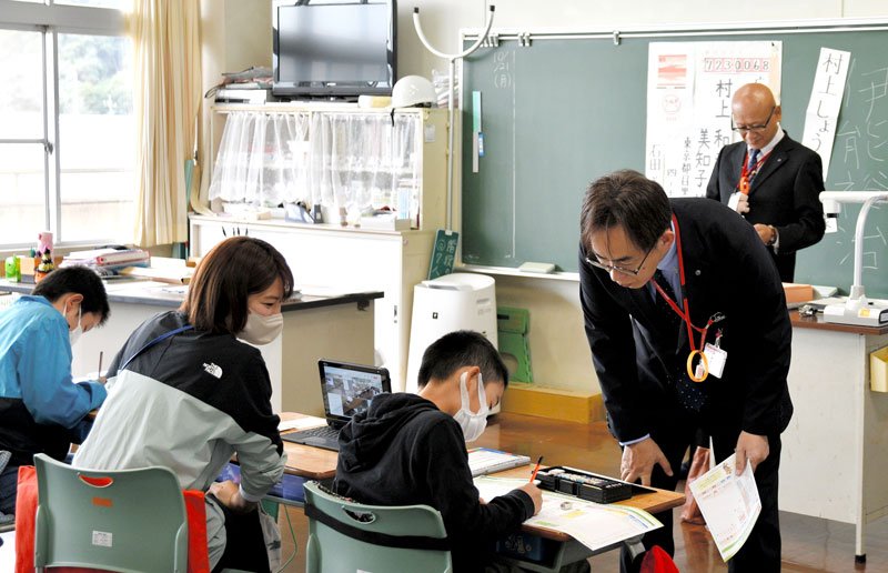郵便局長らから年賀状の書き方を学ぶ児童＝香取市立水の郷小学校