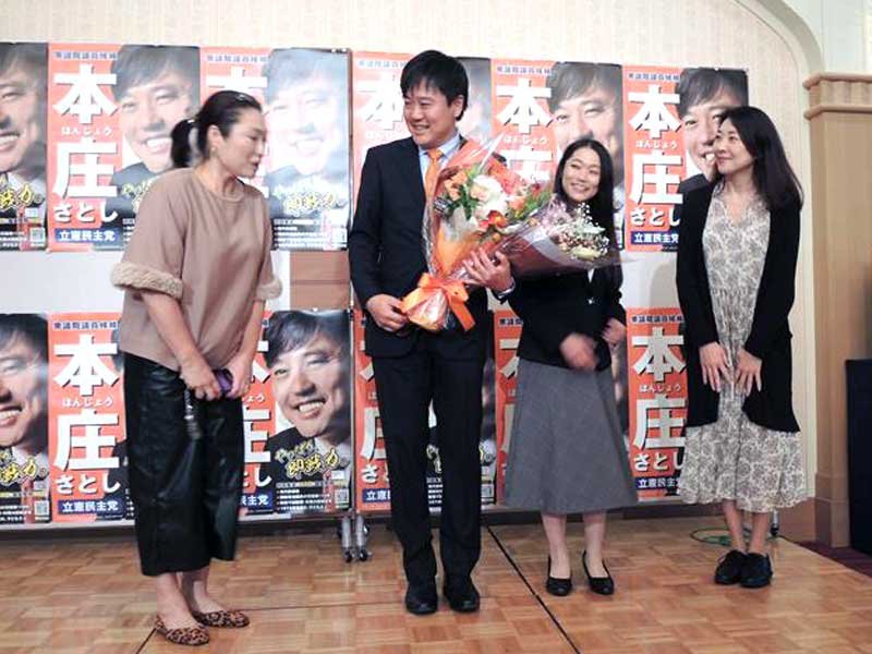 選挙スタッフから花束を受け取り笑顔を見せる立憲民主党の本庄氏＝２７日、柏市