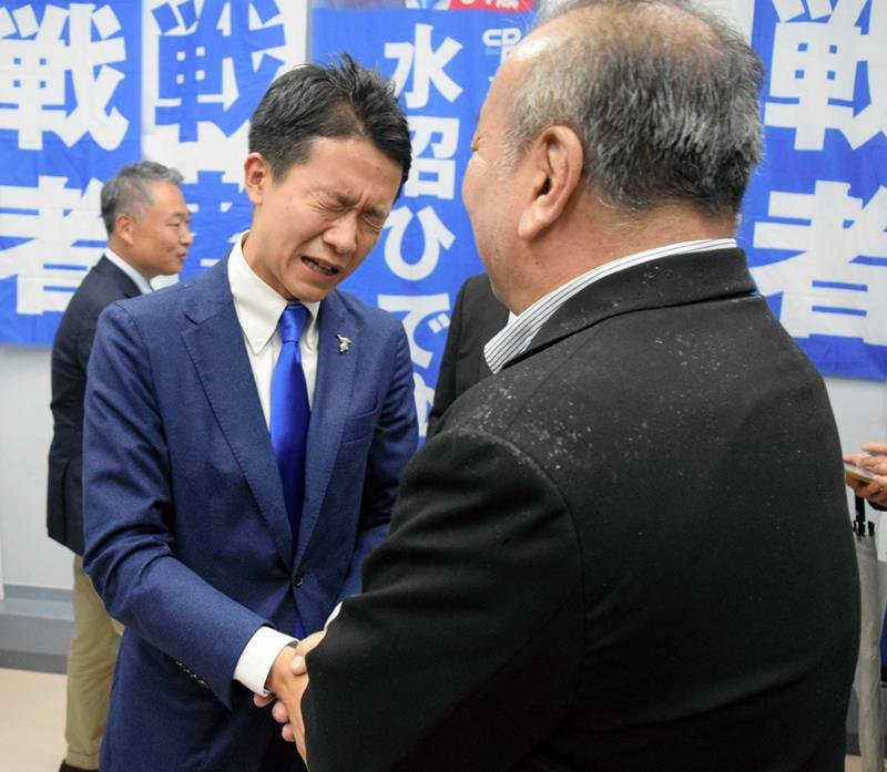 初当選を決め、支持者と握手する水沼氏＝２７日、船橋市
