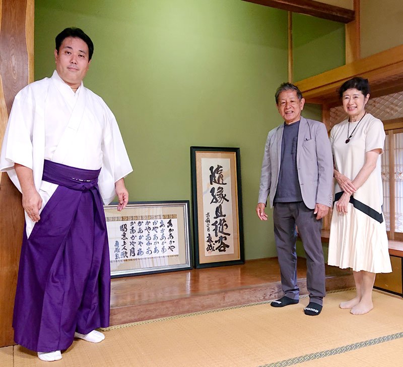 立野有文さん（右から２人目）が奉納した２点の書。左は平沢宮司＝市原市の飯香岡八幡宮
