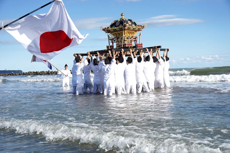 海に漬かりながら息を合わせてみこしを上げる若者ら＝７日、旭市
