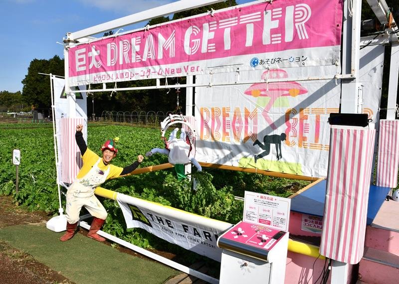 クレーンゲーム機を使ってダイコンの収穫を実演したヤサイちゃん（左）ら＝２７日、香取市
