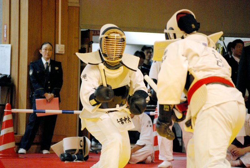 団体戦決勝で警棒を手に立ち合う空港警備隊警備室の選手（手前）と千葉中央署の選手（奥）＝千葉市稲毛区の県総合スポーツセンター武道館