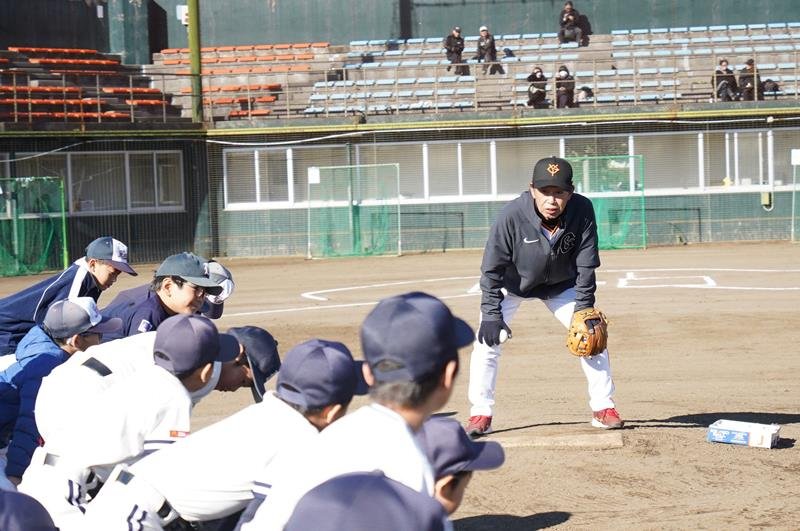 小学生に守備の指導をする講師の篠塚さん＝旭市
