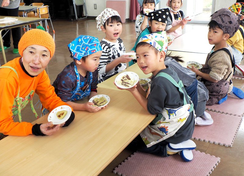 「さつまいももち」が出来上がり、大喜びの子どもたちと平田さん（左）＝２７日、富津市
