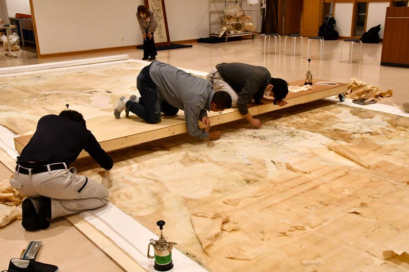 壁画裏面の修復作業を進める人たち＝２月７日、千葉市美術館