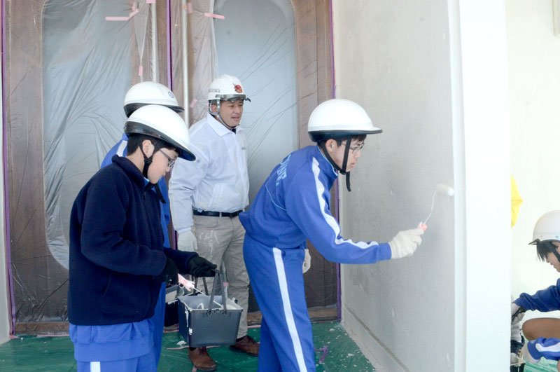 東金中体育館の外壁を塗り直す同校の生徒ら＝東金市
