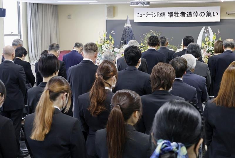 富山外国語専門学校の追悼の集いで黙とうする参列者＝２２日午前、富山市（共同）
