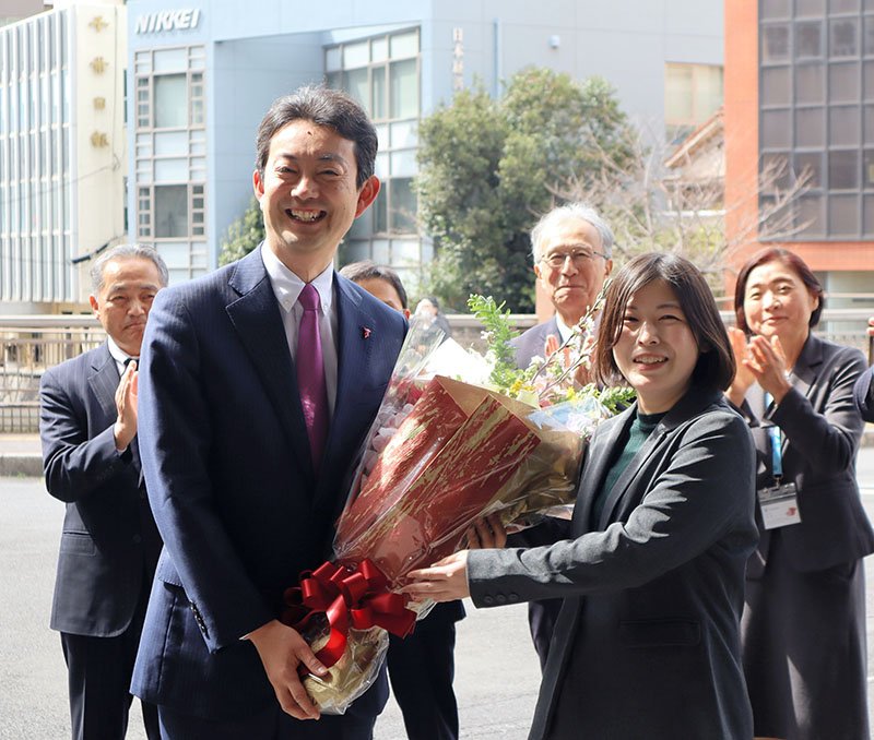 職員から花束を受け取り笑顔を見せる熊谷知事＝１８日、県庁