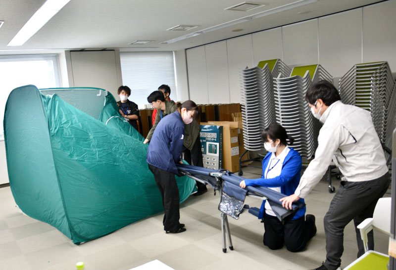 パーティションやベッドの取り扱いを学ぶ市職員＝香取市役所