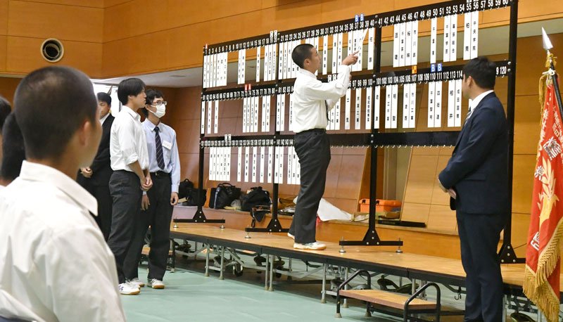 第１０７回全国高校野球選手権千葉大会組み合わせ抽選会で、校名札をかける主将＝１２日、千葉市稲毛区
