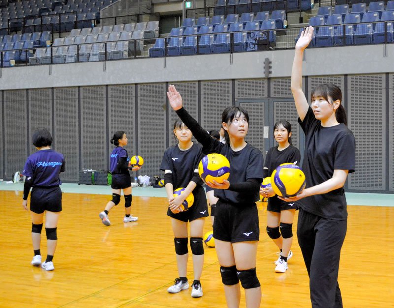 新鍋さん（右）からサーブの指導を受ける中学生たち＝千葉市中央区