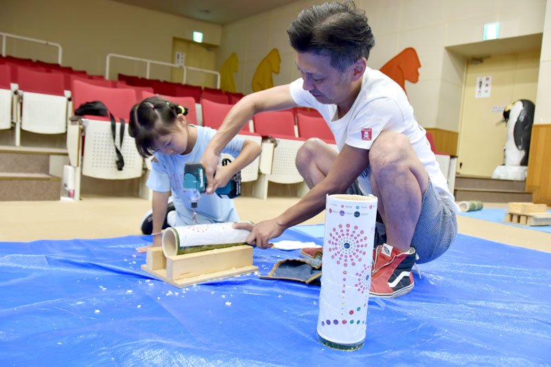 竹に台紙を貼り、ドリルで穴を開ける参加者＝千葉市若葉区
