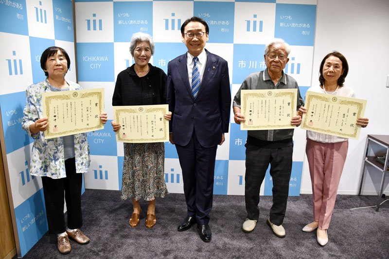 表彰状を受け取った「いちかわ文芸年間賞」の受賞者ら。中央は田中市長＝市川市役所
