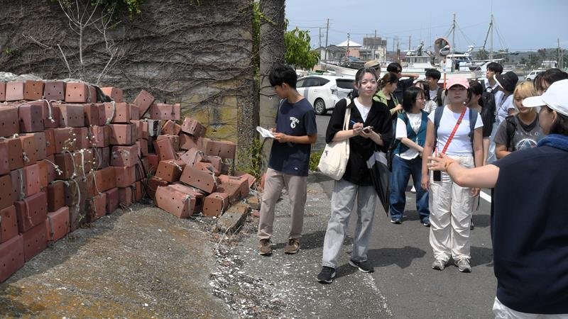 大原漁港周辺を見て回る千葉大と台湾の学生。左端はタコつぼ漁具＝いすみ市
