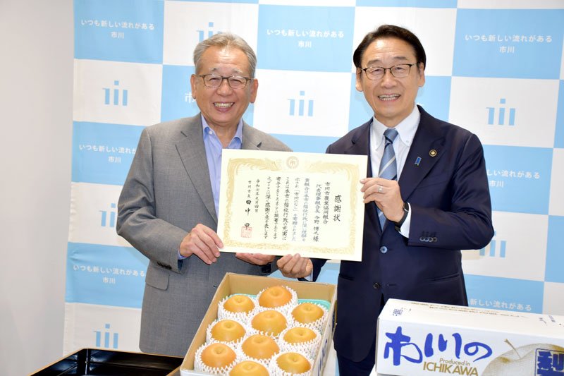 田中市長（右）に福祉施設に寄贈する梨を届けた今野組合長＝市川市役所
