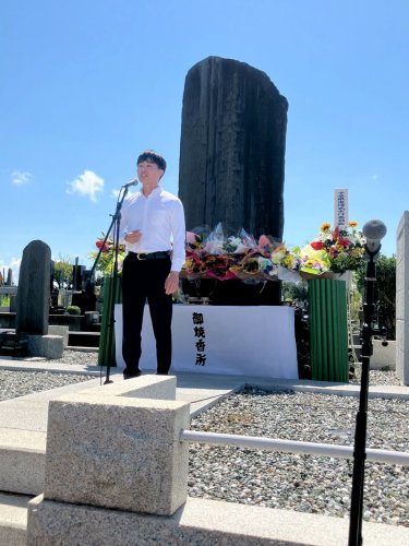 慰霊碑の前で歌う金さん＝７日、船橋市の馬込霊園