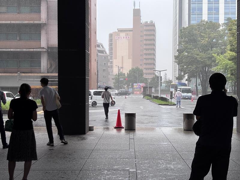 激しい雨が弱まるのを待つ人たち＝１２日午後０時５５分ごろ、千葉市中央区
