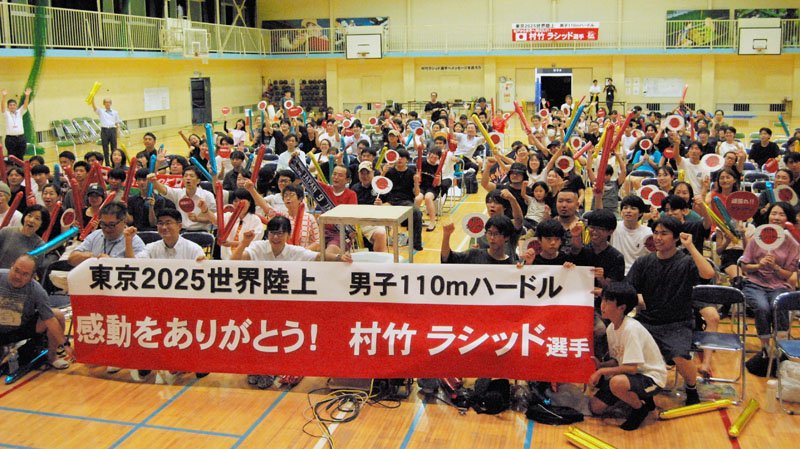 世界陸上で５位に入った村竹ラシッド選手をたたえる横断幕を掲げて「感動をありがとう」と伝える後輩や市民ら＝１６日午後１０時半ごろ、松戸市岩瀬の同市立第一中学校