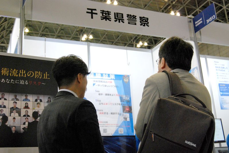 シーテックの会場で、県警外事課員が、ブースを訪れた来場者に技術流出の防止について説明した＝１６日、千葉市美浜区の幕張メッセ