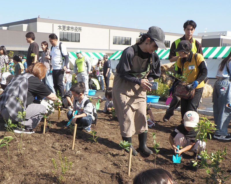 木更津市役所朝日新庁舎の開庁に先立ち、苗木を植樹する親子ら＝木更津市