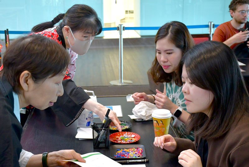 成田空港で水引を使ったネームタグ作りを体験する旅客ら＝成田市
