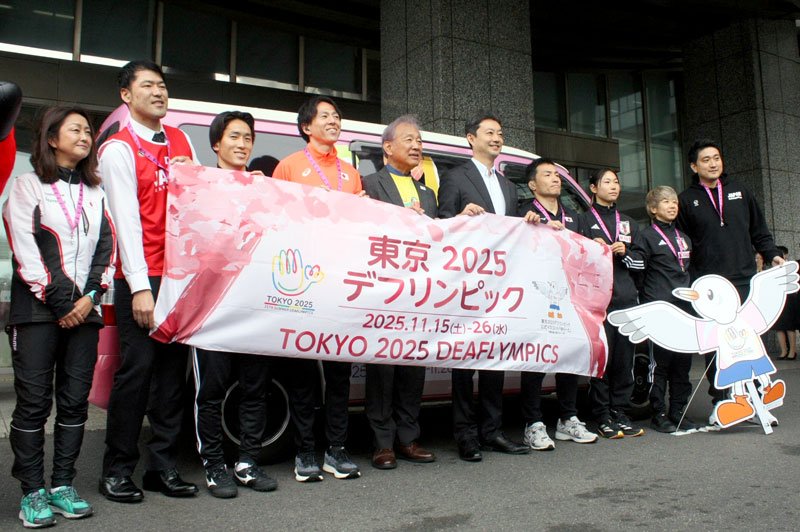 キャラバンカーの前で横断幕を掲げ、大会をＰＲする熊谷知事と千葉県ゆかりの選手ら＝２２日、県庁