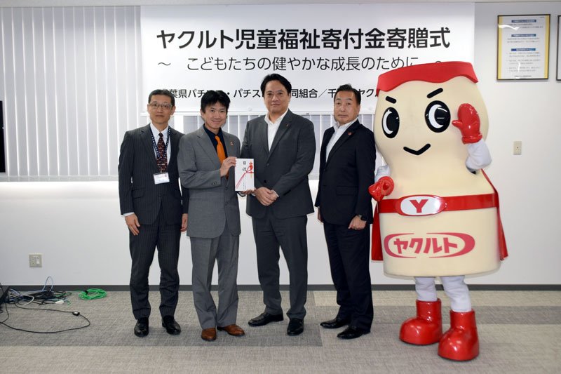 ヤクルト児童福祉寄付金寄贈式で目録を手渡す星山理事長（左から３人目）と赤田社長（同４人目）＝習志野市