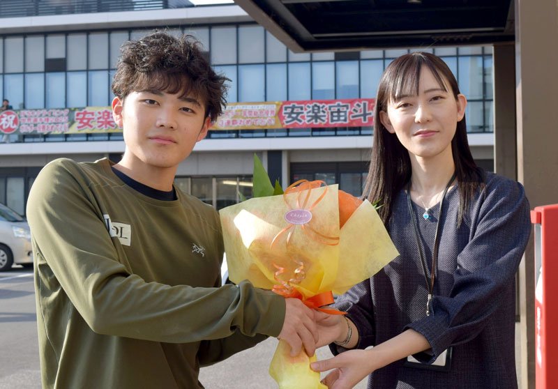 市職員（右）から花束を贈られる安楽選手＝１４日、八千代市役所