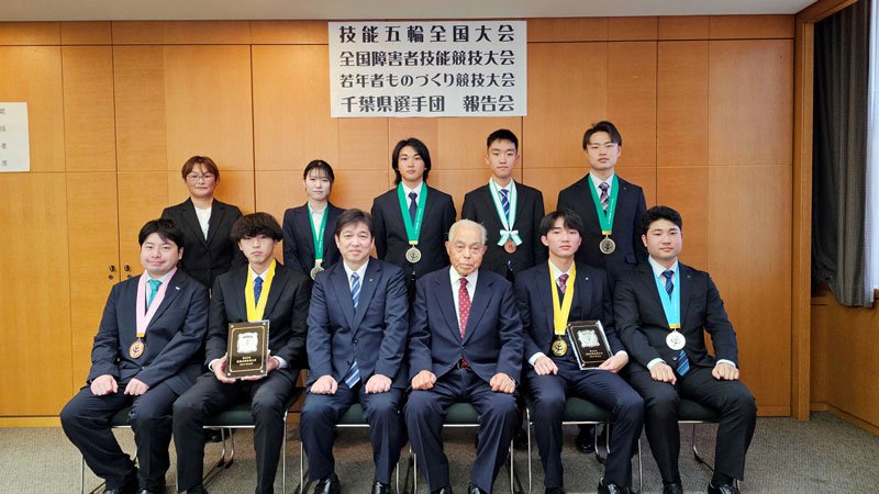 関雄二商工労働部長（前列左から３人目）と記念撮影をする出場者ら＝県庁