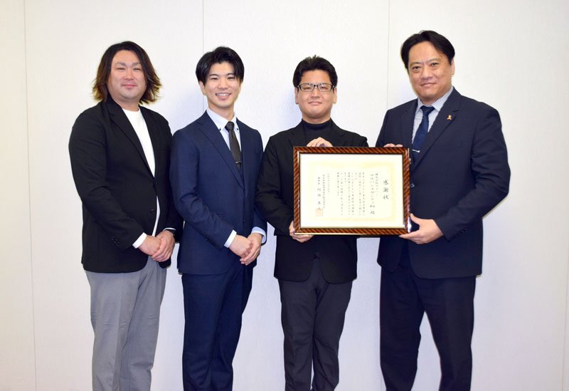 星山理事長（右）から感謝状を受け取る堀さん（右から２人目）、鈴木マネジャー（同３人目）、杉原さん（同４人目）
