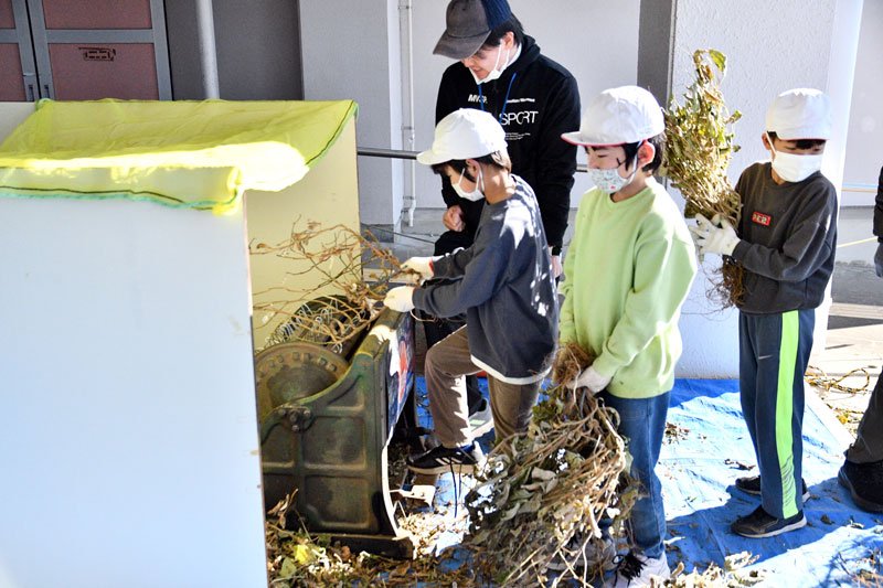 足踏み式の脱穀機を使い、大豆の実を取り出す児童たち＝１０日、神崎町立米沢小学校