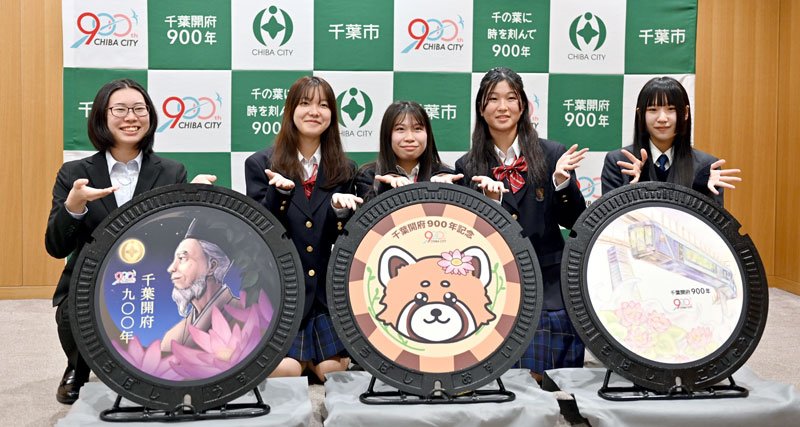 千葉開府９００年を記念したデザインマンホールふたに選ばれた３作品とデザインした学生ら＝千葉市役所