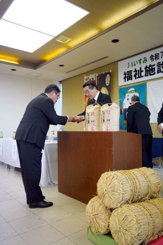 福祉施設関係者（左）に新米の目録を手渡す高地組合長＝いすみ市