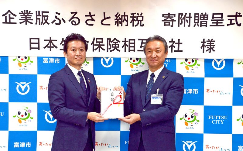 高橋市長（右）に目録を渡す鈴木支社長＝富津市役所
