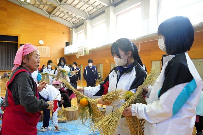 婦人会の女性に教わりながら正月飾りを仕上げる生徒＝勝浦市
